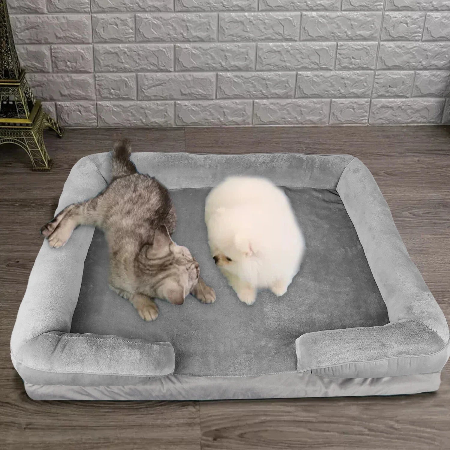 Two dogs on a comfortable pet bed against a stone wall background